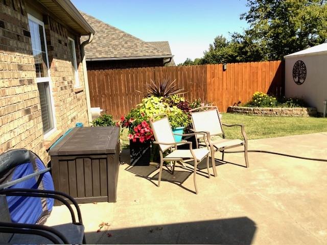 3809 N 2nd Pl, Rogers, AR 72756 - fenced backyard with a patio area
