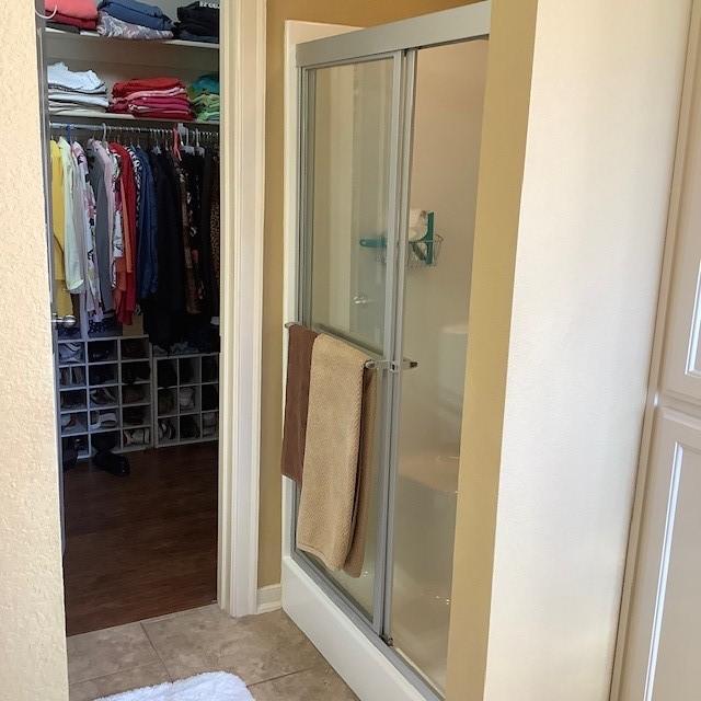 3809 N 2nd Pl, Rogers, AR 72756 - bathroom with a shower stall, tile patterned flooring, and a walk in closet
