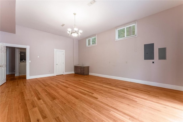 14074 Old Mill Rd, Elkins, AR 72727 - unfurnished room with light wood-style flooring, a chandelier, and electric panel