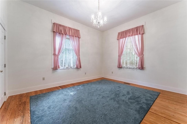 14074 Old Mill Rd, Elkins, AR 72727 - spare room with plenty of natural light, a chandelier, and wood finished floors