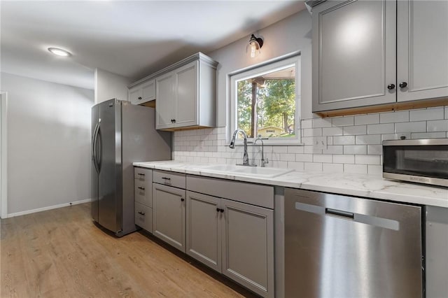 25 Grisham Cir, Bella Vista, AR 72715 - kitchen with appliances with stainless steel finishes, gray cabinetry, tasteful backsplash, light wood-style flooring, and light stone counters