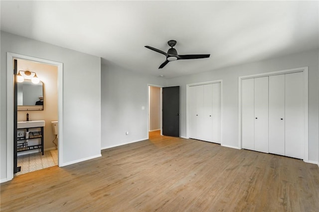 25 Grisham Cir, Bella Vista, AR 72715 - unfurnished bedroom with two closets, wood finished floors, ensuite bath, and ceiling fan