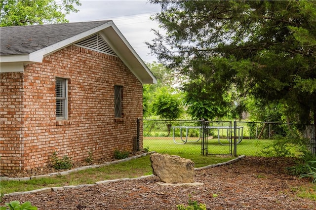 805 S Oak Hill St, Siloam Springs, AR 72761 - view of side of home with a gate, brick siding, and roof with shingles