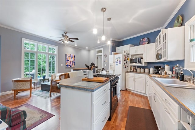 393 Timberlake Ln, Eureka Springs, AR 72631 - kitchen featuring stainless steel microwave, gas range oven, ceiling fan, glass insert cabinets, and white cabinets