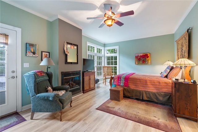 393 Timberlake Ln, Eureka Springs, AR 72631 - bedroom with light wood-style flooring, ornamental molding, a glass covered fireplace, and ceiling fan