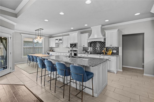 801 Bellmara Cir, Cave Springs, AR 72718 - kitchen with custom range hood, stainless steel appliances, crown molding, a kitchen breakfast bar, and white cabinetry