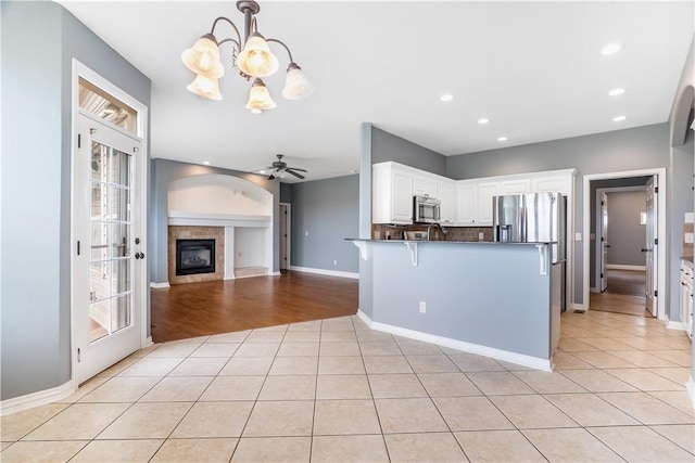 13449 Loyle Ln, Gravette, AR 72736 - kitchen with stainless steel microwave, light tile patterned flooring, a peninsula, dark countertops, and a chandelier