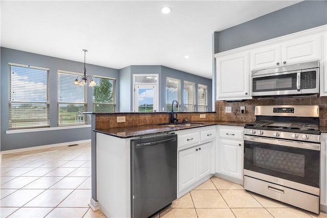 13449 Loyle Ln, Gravette, AR 72736 - kitchen featuring stainless steel appliances, backsplash, light tile patterned floors, white cabinets, and a peninsula