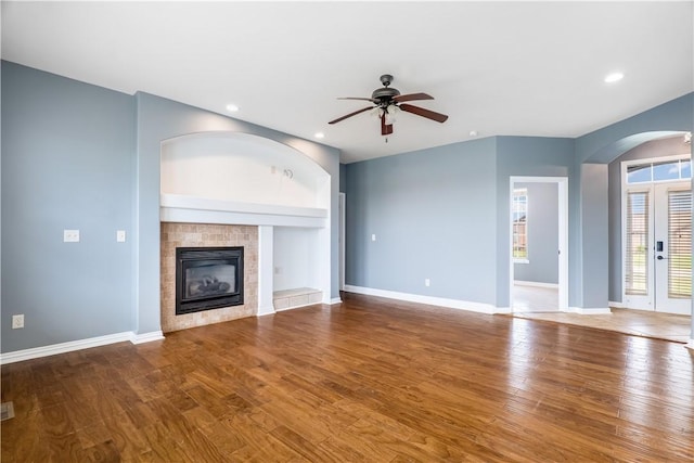 13449 Loyle Ln, Gravette, AR 72736 - unfurnished living room featuring arched walkways, a ceiling fan, a fireplace, wood finished floors, and recessed lighting