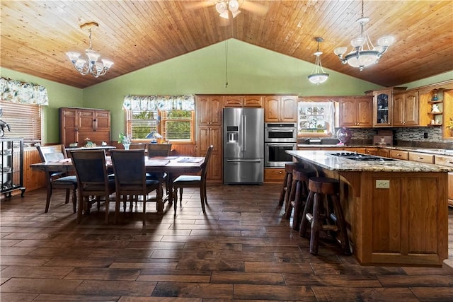 617 County Road 736, Berryville, AR 72616 - kitchen featuring appliances with stainless steel finishes, a chandelier, brown cabinets, dark wood-style flooring, and a kitchen island
