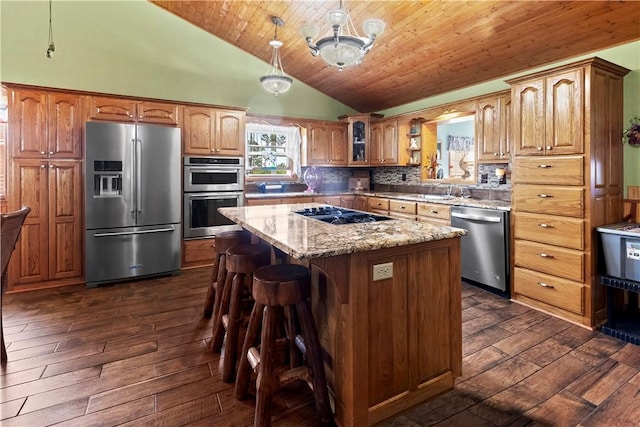 617 County Road 736, Berryville, AR 72616 - kitchen featuring appliances with stainless steel finishes, dark wood-style floors, a center island, a kitchen bar, and light stone countertops