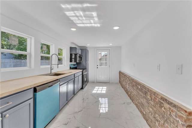 408 SW 2nd Ave, Gravette, AR 72736 - kitchen featuring appliances with stainless steel finishes, recessed lighting, light marble finish floors, butcher block counters, and gray cabinets