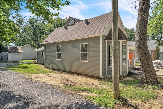408 SW 2nd Ave, Gravette, AR 72736 - view of side of property with a shingled roof and a shed