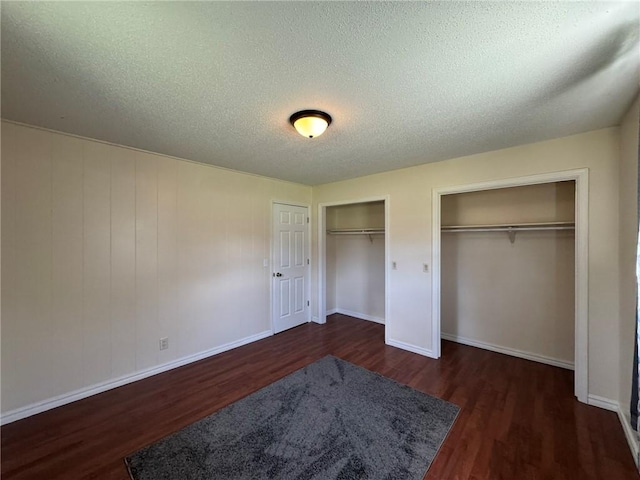 811 Overlook Dr, Mountain Home, AR 72653 - unfurnished bedroom featuring multiple closets, wood finished floors, and a textured ceiling