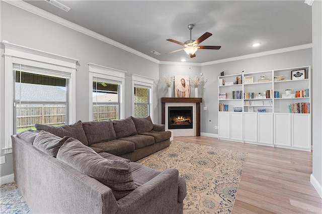 1001 Kimball Ln, Pea Ridge, AR 72751 - living area with light wood finished floors, a ceiling fan, a lit fireplace, ornamental molding, and recessed lighting