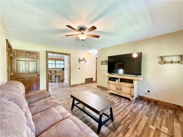 8500 Rock Creek Rd, Mulberry, AR 72947 - living room featuring light wood-type flooring, ceiling fan, and a textured ceiling