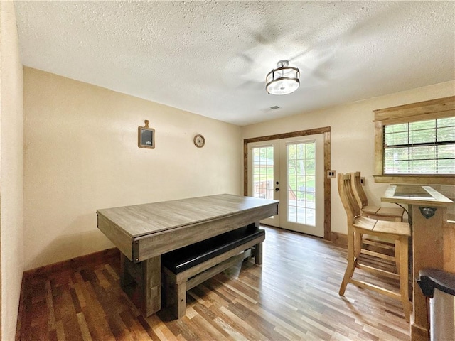 8500 Rock Creek Rd, Mulberry, AR 72947 - dining space featuring french doors, light wood-style floors, healthy amount of natural light, and a textured ceiling