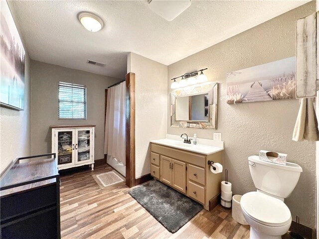 8500 Rock Creek Rd, Mulberry, AR 72947 - full bathroom featuring a textured wall, vanity, wood finished floors, a textured ceiling, and curtained shower