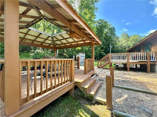 8500 Rock Creek Rd, Mulberry, AR 72947 - wooden deck featuring a gazebo, a storage unit, and view of scattered trees