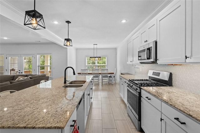 108 Dobson St, Pea Ridge, AR 72751 - kitchen featuring appliances with stainless steel finishes, tasteful backsplash, white cabinetry, an island with sink, and light stone counters