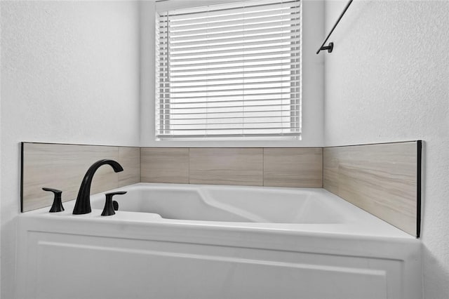108 Dobson St, Pea Ridge, AR 72751 - bathroom with plenty of natural light, a bath, and a textured wall
