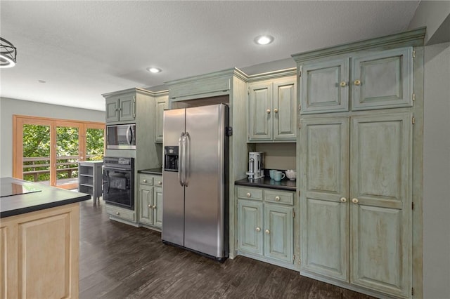 9382 Grimes Dr, Rogers, AR 72756 - kitchen featuring stainless steel fridge, black oven, dark countertops, dark wood-style flooring, and recessed lighting