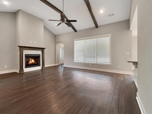 217 Idaho Ave, Farmington, AR 72730 - unfurnished living room featuring ceiling fan, dark wood-type flooring, beam ceiling, a high end fireplace, and arched walkways