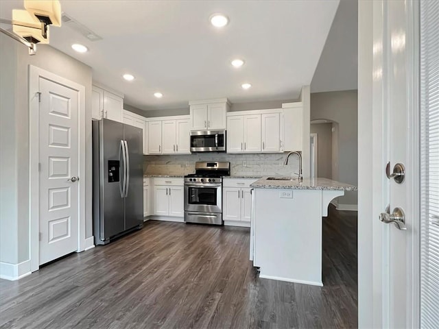 217 Idaho Ave, Farmington, AR 72730 - kitchen featuring stainless steel appliances, arched walkways, a peninsula, light stone counters, and white cabinets