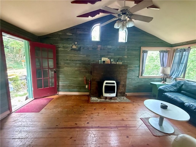 16 Nut St, Eureka Springs, AR 72632 - living room featuring heating unit, vaulted ceiling, wood-type flooring, wood walls, and ceiling fan