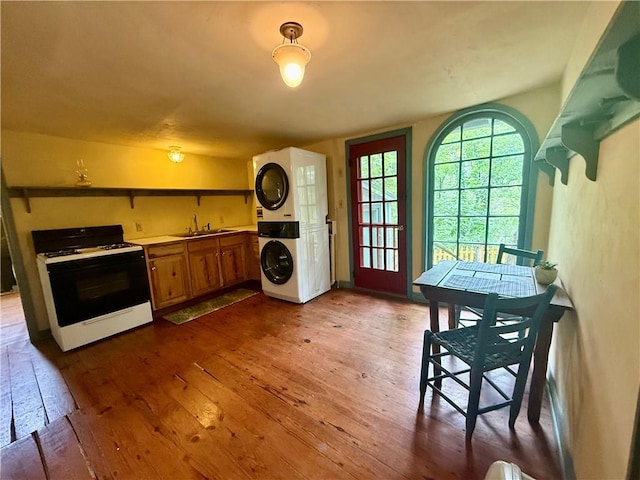 16 Nut St, Eureka Springs, AR 72632 - kitchen featuring gas range gas stove, estacked washer and dryer, dark wood-style floors, and brown cabinetry