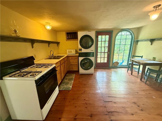16 Nut St, Eureka Springs, AR 72632 - kitchen with white appliances, stacked washer / dryer, hardwood / wood-style flooring, open shelves, and brown cabinets