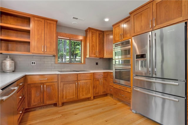 1018 N Canterbury Rd, Fayetteville, AR 72701 - kitchen with stainless steel appliances, brown cabinets, light countertops, light wood finished floors, and recessed lighting
