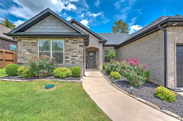 1208 Hickory St, Cave Springs, AR 72718 - view of front of property with a front yard, stone siding, and brick siding