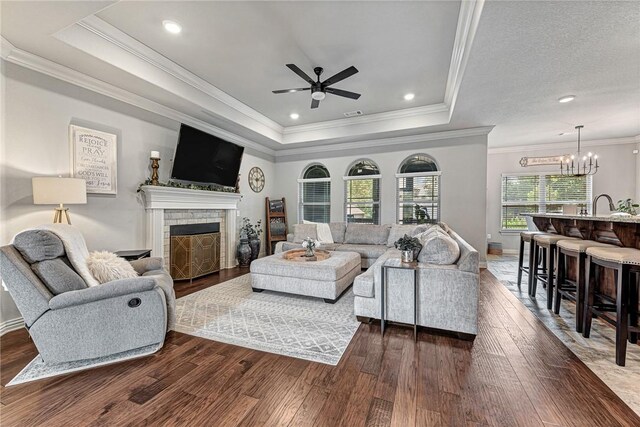 1208 Hickory St, Cave Springs, AR 72718 - living room with a ceiling fan, dark wood-type flooring, a brick fireplace, and ornamental molding