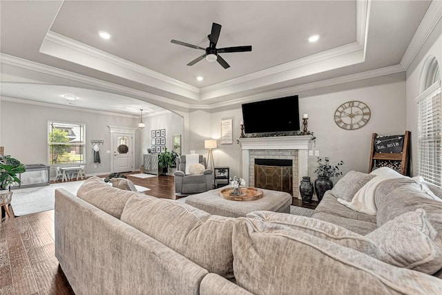 1208 Hickory St, Cave Springs, AR 72718 - living area featuring a raised ceiling, arched walkways, a ceiling fan, dark wood-style flooring, and a fireplace