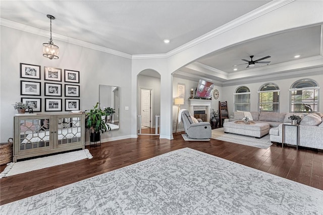1208 Hickory St, Cave Springs, AR 72718 - living area with wood finished floors, a ceiling fan, arched walkways, crown molding, and a fireplace