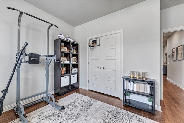 1208 Hickory St, Cave Springs, AR 72718 - exercise room featuring wood finished floors and baseboards