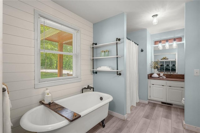 16590 Roughton Ln, Pea Ridge, AR 72751 - bathroom with wood finished floors, wooden walls, a freestanding bath, vanity, and a shower with shower curtain
