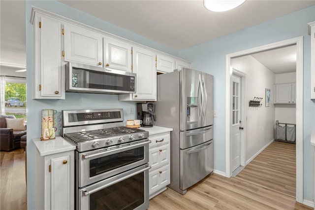 16590 Roughton Ln, Pea Ridge, AR 72751 - kitchen with appliances with stainless steel finishes, light wood finished floors, white cabinetry, and light countertops