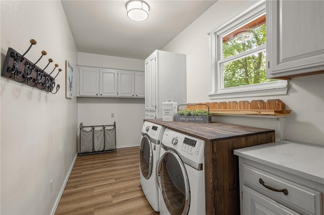 16590 Roughton Ln, Pea Ridge, AR 72751 - laundry area featuring washer and dryer, light wood-type flooring, and cabinet space