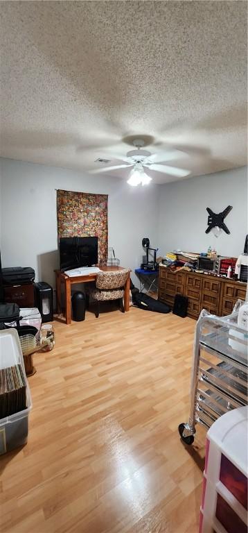 1210 Spring St, Bentonville, AR 72712 - living area with wood finished floors, a textured ceiling, and ceiling fan