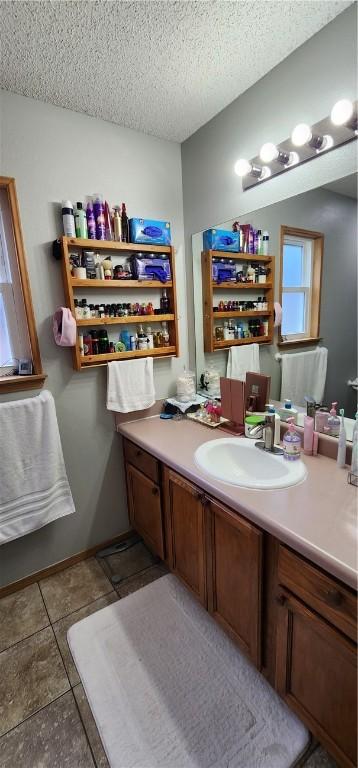 1210 Spring St, Bentonville, AR 72712 - bathroom with vanity, a textured ceiling, and tile patterned floors