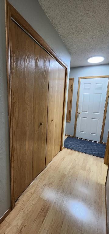 1210 Spring St, Bentonville, AR 72712 - hall featuring light wood-style floors and a textured ceiling