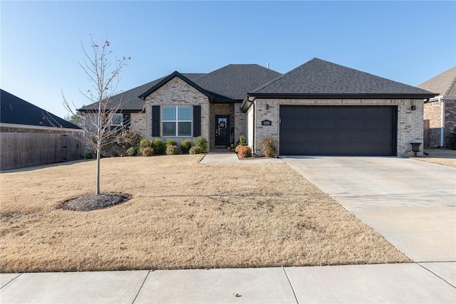 1355 NE Pershing St, Fayetteville, AR 72704 - view of front facade with a garage, concrete driveway, a shingled roof, and brick siding