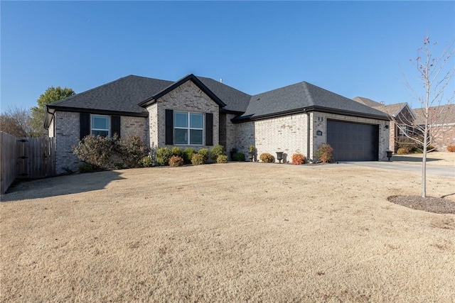 1355 NE Pershing St, Fayetteville, AR 72704 - view of front of house with brick siding, a garage, driveway, and roof with shingles