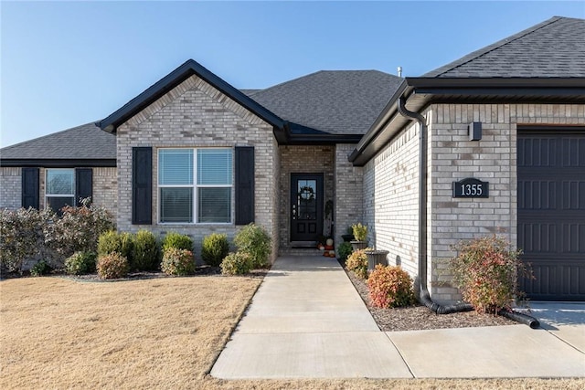 1355 NE Pershing St, Fayetteville, AR 72704 - view of front of house featuring roof with shingles, brick siding, and a garage