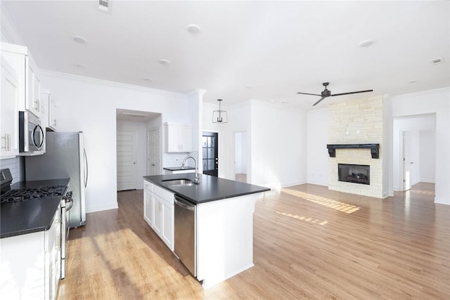 1355 NE Pershing St, Fayetteville, AR 72704 - kitchen with appliances with stainless steel finishes, dark countertops, ceiling fan, white cabinetry, and a kitchen island with sink