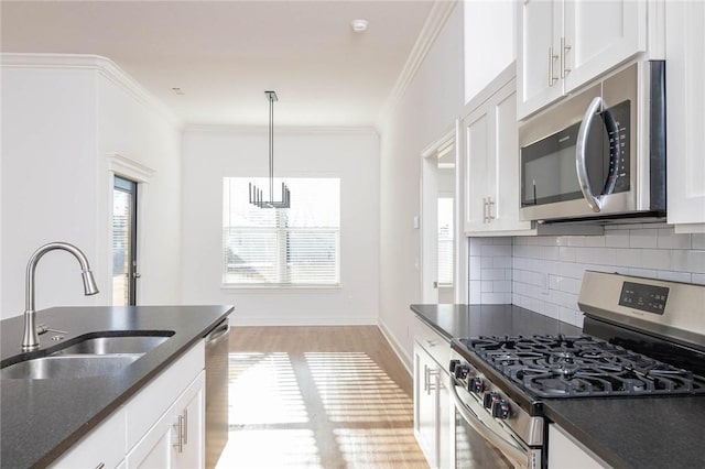 1355 NE Pershing St, Fayetteville, AR 72704 - kitchen featuring stainless steel appliances, backsplash, white cabinetry, light wood finished floors, and crown molding