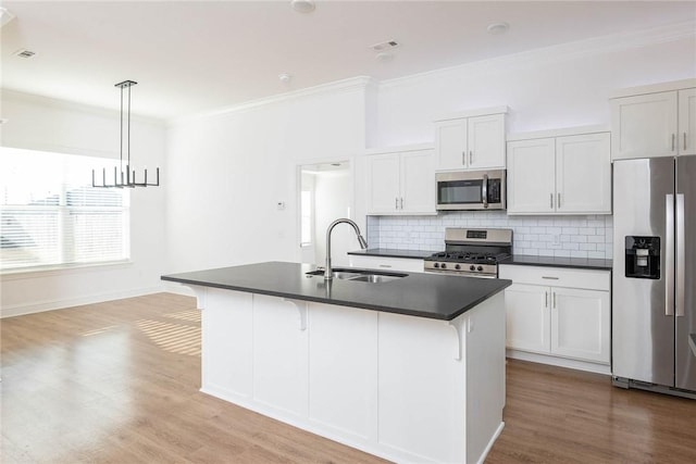 1355 NE Pershing St, Fayetteville, AR 72704 - kitchen with stainless steel appliances, dark countertops, crown molding, decorative backsplash, and a kitchen island with sink