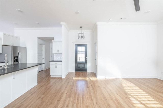 1355 NE Pershing St, Fayetteville, AR 72704 - kitchen featuring stainless steel refrigerator with ice dispenser, dark countertops, white cabinetry, light wood-style floors, and a kitchen breakfast bar